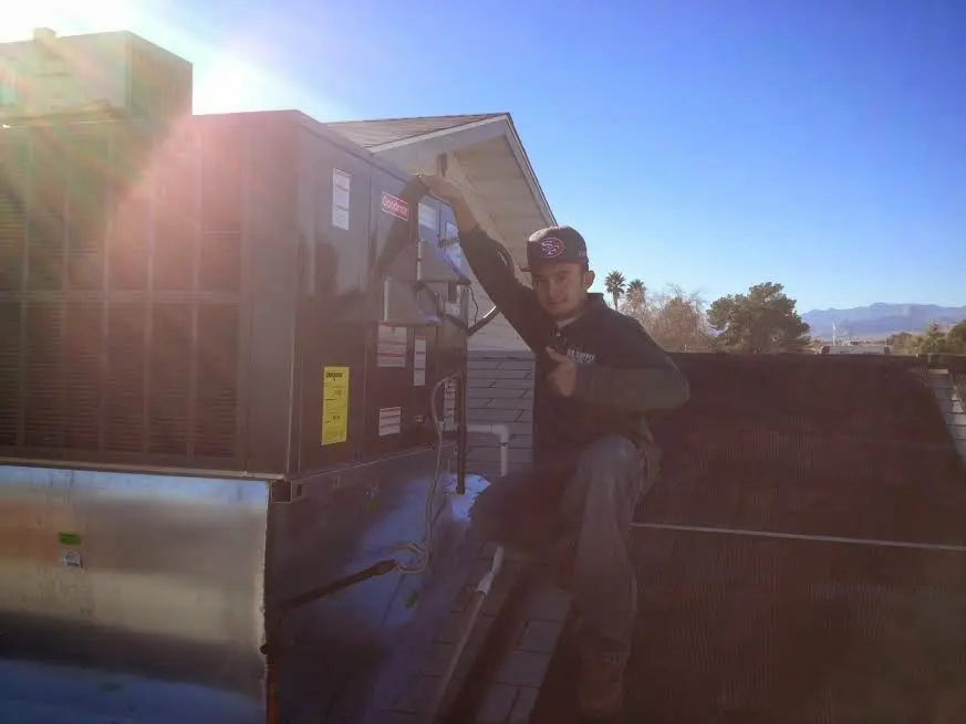 HVAC technician performing Heat Pump Repair on a rooftop unit in Thornton